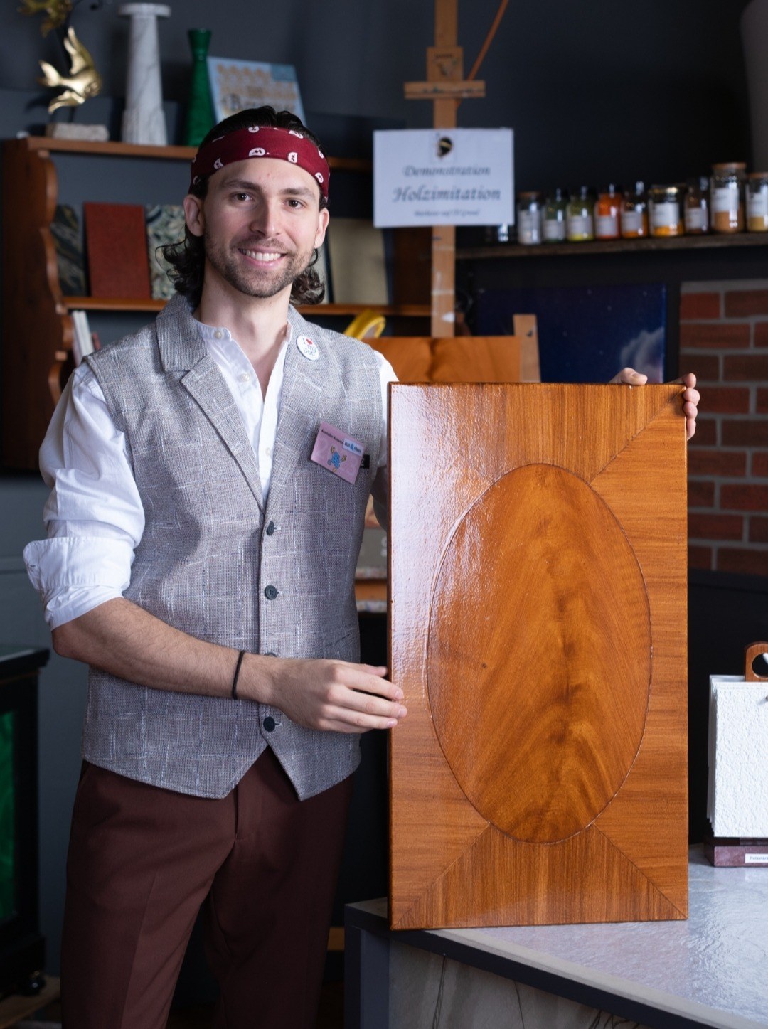 Adrian Kunz mit einem Brett in Mahagoni-Imitation
